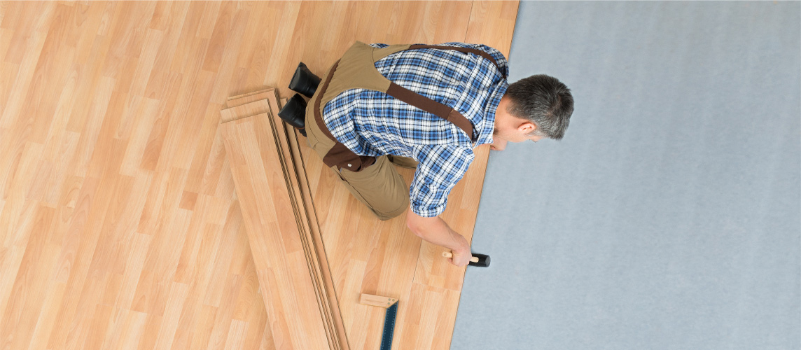 Hardwood plank being laid over foam underlay during installation