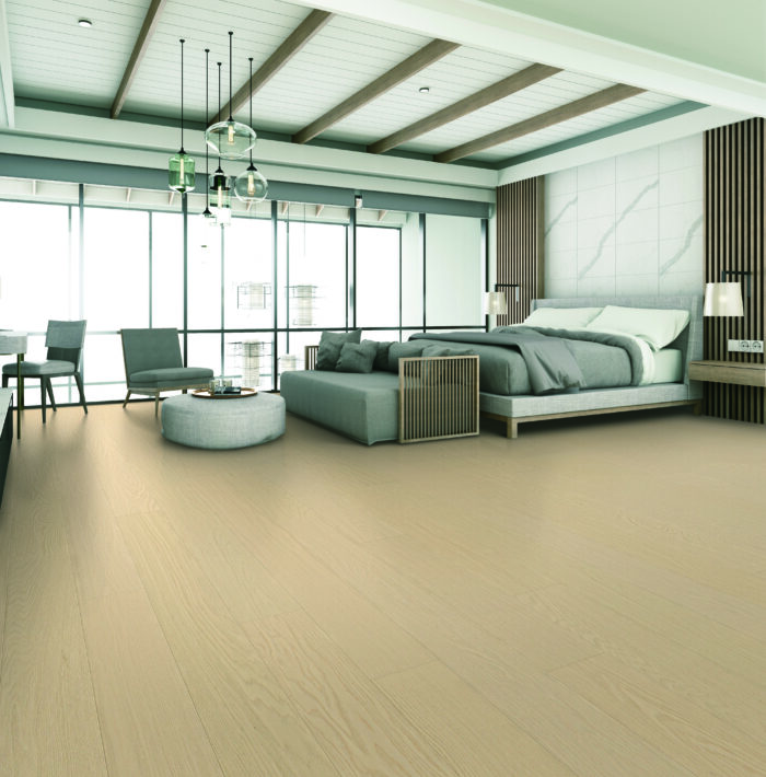 The bedroom is decorated in a modern style with wooden tones with seating and bed and wall decoration. With large windows and high ceilings on parquet floors.
