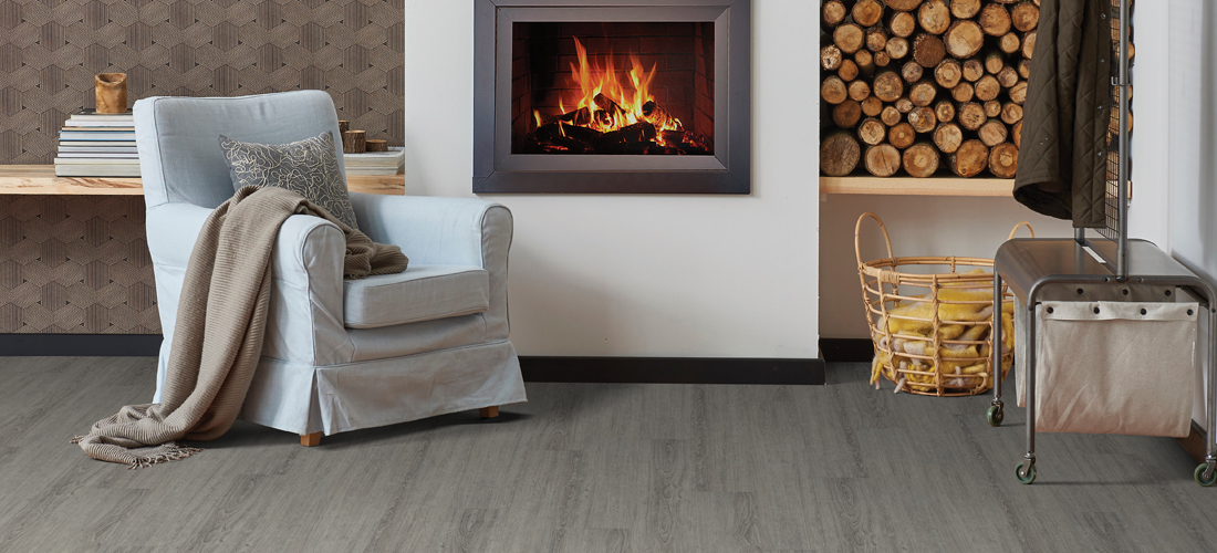 Warm vinyl plank flooring beside a lit fireplace