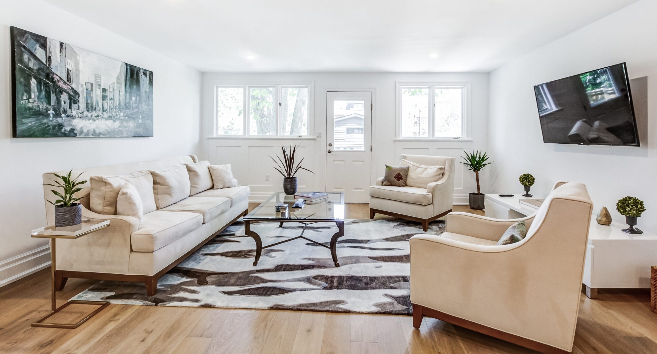 Large area rug over hardwood flooring in a furnished living room