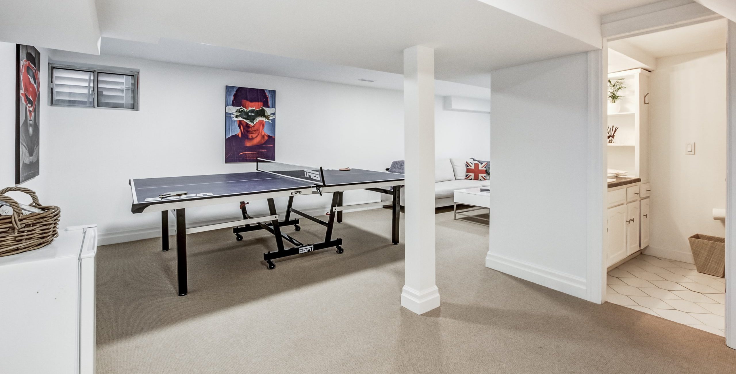 Finished basement rec room with wall-to-wall carpet installed over a concrete slab